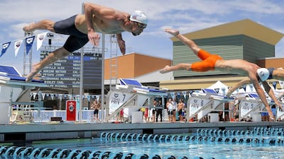 American Michael Phelps, left, dives in during the Arena Grand Prix swim event on Friday in Phoenix, Arizona, ending a two-year absence from competition. Matt York / AP Photo / April 2014