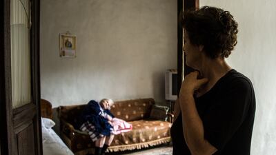 Norma Younes, 74, watches over her 97-year-old mother from the doorway. She receives the medication she needs herself from Ms Comair and her mother's wheelchair also came from the volunteer-run clinic.