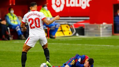 Barcelona's Lionel Messi holds his face after a challenge by Diego Carlos of Sevilla. Reuters