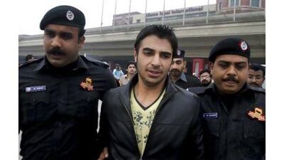 Salman Butt, Pakistan's ex-captain, is escorted to his car on his arrival in Lahore yesterday. KM Chaudary / AP Photo