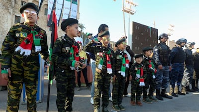 Libyans children dressed in military fatigue stand at attention during a gathering to commemorate the ninth anniversary of the uprising against former Libyan leader Moamer Kadhafi, in the capital Tripoli. AFP