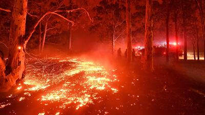 Burning embers cover the ground as firefighters battle against bushfires. AFP