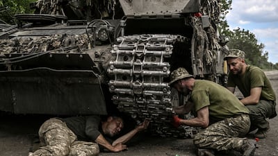 Ukrainian troops repair a tank in the Donbas region. AFP
