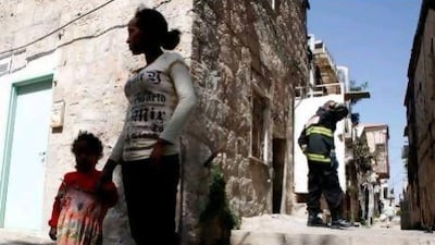 An Eritrean woman with her daughter outside an apartment in Jerusalem that was set ablaze. Israel said it will step up deportation plans for 25,000 African migrants and jail those who try to enter the country.