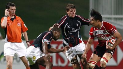 Japan's Shoji Ito, right, challenges UAE's George Perkins, left, and Eddie Talbot during their Asian Five Nations rugby match at the Sevens stadium in Dubai. AFP PHOTO/KARIM SAHIB