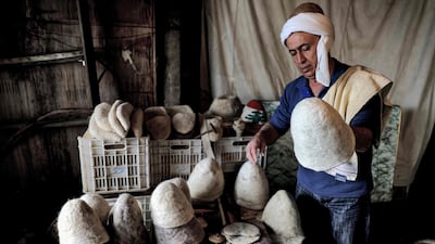 Hatmaker Youssef Akiki inspects some of his traditional 'Labbadeh' hats at his workshop in the mountain town of Hrajel in Lebanon. AFP