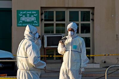 Bahraini policemen seal off a building housing foreign workers in the Salmabad industrial area as a precautionary measure after a resident tested positive for coronavirus (COVID-19), on the outskirts of the capital Manama on March 13, 2020. / AFP / Mazen Mahdi