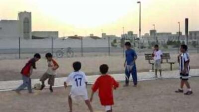 As the sun sets in Al Falah a group of local children come out to play football.