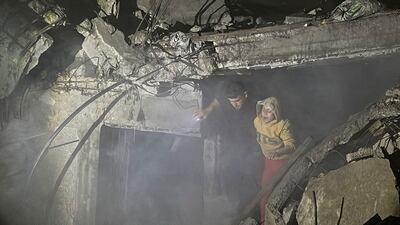 Palestinians make their way through the dust and rubble after the Israeli air strike on the Nuseirat camp in central Gaza. Reuters
