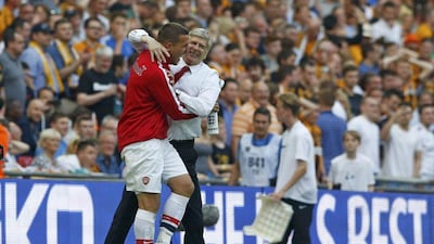 Arsenal's Lukas Podolski hugs manager Arsene Wenger as they celebrate their victory against Hull City in the FA Cup final at Wembley Stadium on Saturday. Darren Staples / Reuters / May 17, 2014