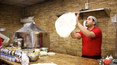 A chef at a restaurant in old Dubai throws and spins dough to make the perfect Egyptian pizza. Courtesy: Frying Pan Adventures
