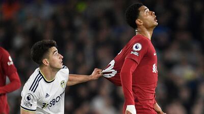 Leeds United midfielder Marc Roca pulls the shirt of Liverpool striker Cody Gakpo. AFP