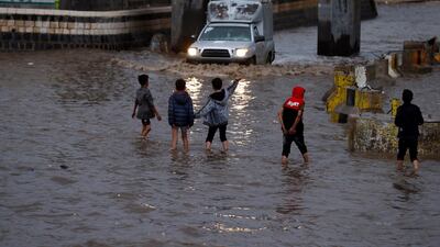 Yemeni children walk through a flooded street following heavy rains in the old quarter of Sanaa, Yemen. EPA
