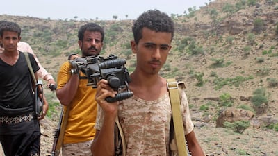 Yemeni pro-government fighters carry a heavy machine gun.