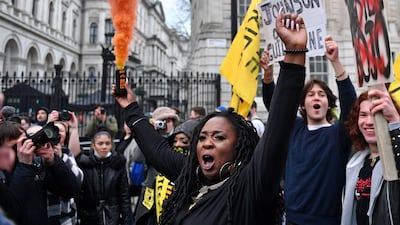 A demonstrator holds a flare in a march to protest against the Police, Crime, Sentencing and Courts Bill, outside the entrance to Downing Street, in London in January 2022. AFP