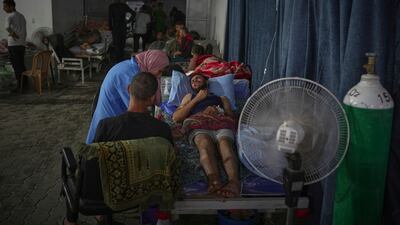 A nurse treats a wounded person inside a warehouse constructed in the yard of the hospital.