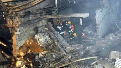 Firefighters search the rubble of an internet cafe in China following an explosion.