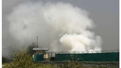 A Nato helicopter flies above the scene of a raid as smoke rises from a base in Jalalabad on Wednesday, June 30, 2010.