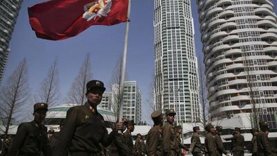 North Korean soldiers carry the Korean People's Army flag as they walk past residential buildings along Ryomyong street, in Pyongyang, North Korea. Wong Maye-E / AP Photo