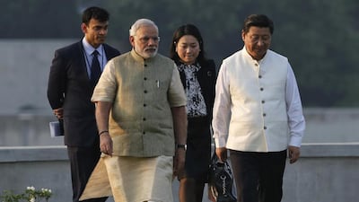 Narendra Modi, front left, dressed in his trademark half-sleeved kurta and churidar pyjama, with the Chinese president Xi Jinping, right. Amit Dave / Reuters