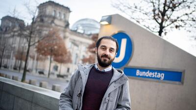 Syrian refugee Tarek Alaows in front of the Reichstag, the seat of the Bundestag, with the adjacent underground station in Berlin also seen in the background, on March 2, 2021. AFP