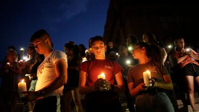 Samuel Lerma, Arzetta Hodges and Desiree Qunitana join mourners taking in a vigil at El Paso High School. Reuters