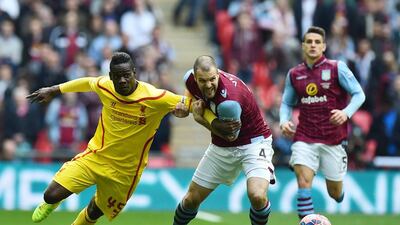 Aston Villa's Ron Vlaar vies for the ball with Liverpool's Mario Balotelli during their FA Cup semi-final match on Sunday. Ben Stansall / AFP
