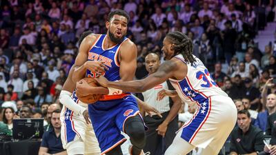 New York Knicks' Karl-Anthony Towns attempts to avoid Jubari Walker of the 76ers.