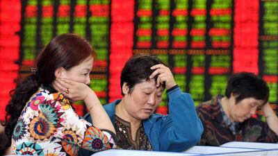 Chinese investors check share prices in Fuyang, east China's Anhui province. The Shanghai Composite Index entered a bear market, after declining by more than 20 per cent from its latest peak. AFP