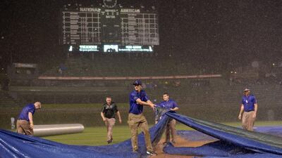 Chicago Cubs ground crew members struggle to get the tarp on the field. AFP