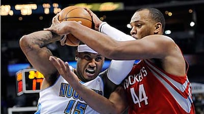 The Nuggets forward Carmelo Anthony, left, is fouled by Rockets center Chuck Hayes during the fourth quarter.