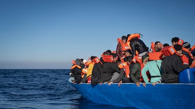 Migrants and refugees, sailing adrift on an overcrowded wooden boat in the Mediterranean Sea, wait to be helped by Spanish NGO Aita Mary. AP Photo