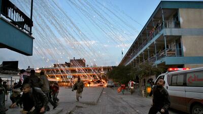 Palestinian civilians and medics run to safety during an Israeli strike over a UN school in Beit Lahia in 2009. Mohammed Abed / AFP