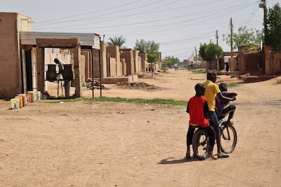 Sudanese ride a bicycle past a water filling area in the capital Khartoum. AFP