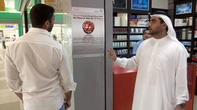 Ahmad Saeed Alnaqaz, right, a municipality officer, explains the campaign to a member of the public in Festival City yesterday.