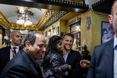 Egyptian President Abdel Fattah El Sisi, left, and French President Emmanuel Macron, right, visit the Umm Kulthum Cafe in central Cairo. AFP