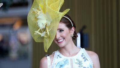 A woman wears an intricate yellow hat and floral dress for the Dubai World Cup. Pawan Singh / The National