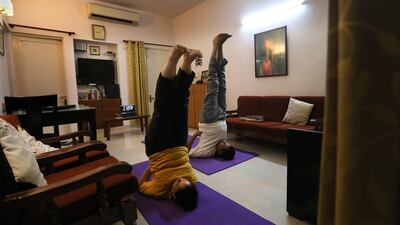 A couple practice yoga at their home through an online class in New Delhi, India. AP Photo