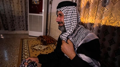 Jasb Hattab Aboud, father of the kidnapped protester Ali Jasb, cries as he holds his son's picture in his home in the town of Amara, Iraq. AP