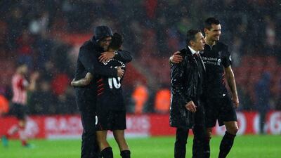 Jurgen Klopp, left, and Philippe Coutinho of Liverpool embrace after the final whistle. Clive Rose / Getty Images