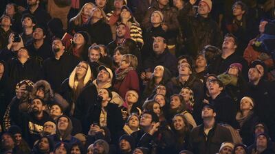 Spectators watch as Mr Wallenda walks on a rope suspended more than 150 metres above the Chicago River between two skyscrapers. John Gress / Reuters