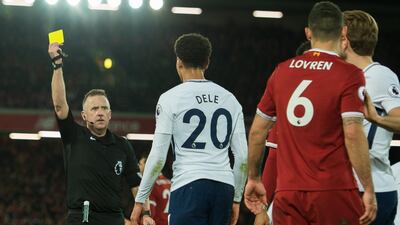 Tottenham's Dele Alli receives a yellow card from referee Jon Moss for diving during the 2-2 Premier League draw against Liverpool at Anfield. Peter Powell / EPA