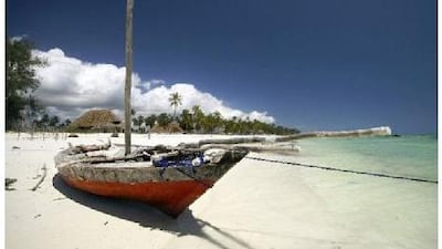An old fishing boat rests on a beach in Zanzibar, a multicultural island off the coast of Tanzania that has been swooned over by travellers for centuries.