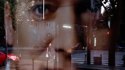 A woman is reflected in a poster depicting Serbian president and the leader of the ruling party Aleksandar Vucic in Belgrade. Reuters
