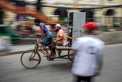 A man transports a fridge on a rickshaw in Dhaka, where Muhammad Yunus led a tribute to Bangladesh's fallen independence heroes. AFP