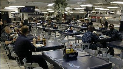 Sailors having lunch in one of the dining areas on board the George H. W. Bush aircraft carrier in port at Jebel Ali.