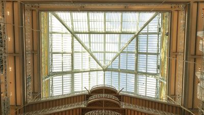 Wrought-iron balconies and banisters stand on the grand staircase beneath the glass roofed atrium of the Samaritaine department store. Bloomberg