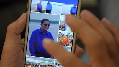 A Cambodian man in Phnom Penh browses through photos of Cambodian Prime Minister Hun Sen on the leader's Facebook page. AFP / TANG CHHIN SOTHY