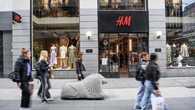 Shoppers pass an H&M shop in central Stockholm, Sweden, on April 2, 2020. The retailer has started dialogue with with tens of thousands of staff about cutting working hours due to the coronavirus pandemic's effect on the market. EPA