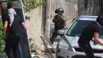 Palestinians take cover from Israeli security forces in the the occupied West Bank on Friday. AFP